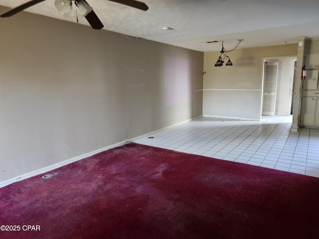 unfurnished room featuring light tile patterned floors, a textured ceiling, a ceiling fan, and baseboards