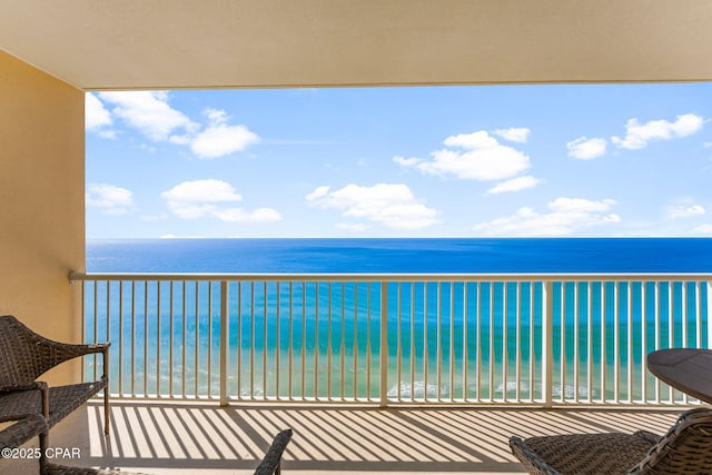 balcony featuring a water view and a beach view