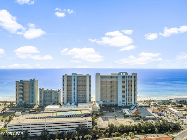 drone / aerial view featuring a view of city, a water view, and a beach view