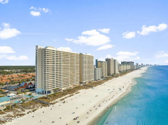 drone / aerial view featuring a city view, a water view, and a beach view