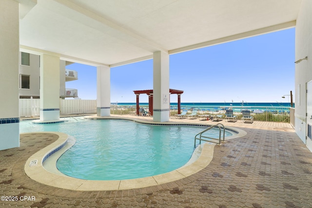 community pool with a water view, a patio area, fence, and a pergola