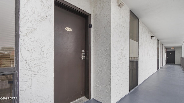 doorway to property featuring stucco siding