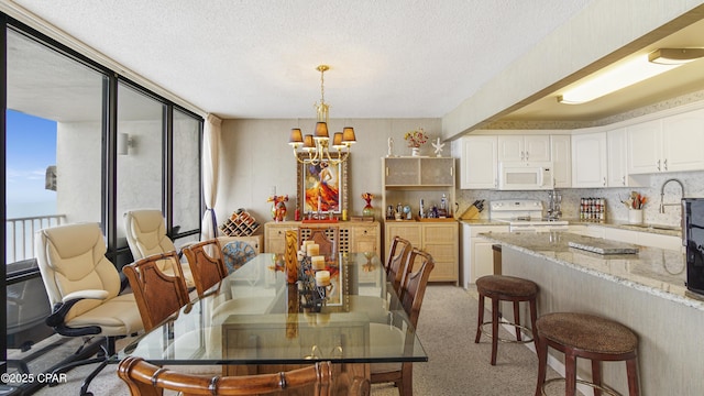 dining space featuring light carpet, a notable chandelier, and a textured ceiling