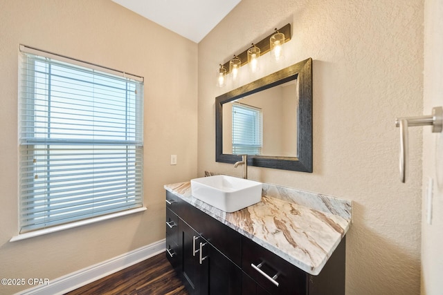 bathroom with baseboards, wood finished floors, and vanity