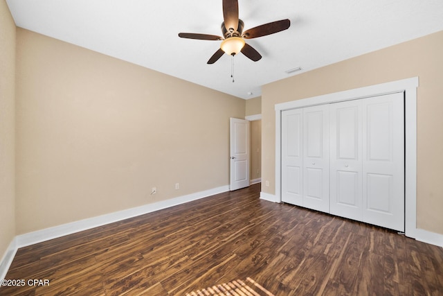 unfurnished bedroom with dark wood-style floors, a closet, visible vents, a ceiling fan, and baseboards