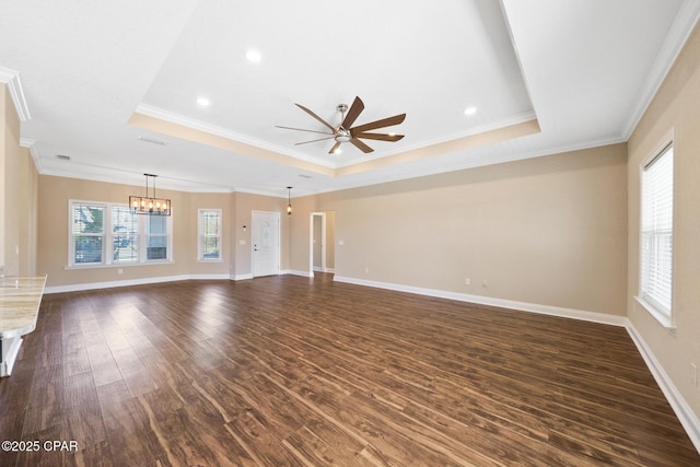 unfurnished living room with a wealth of natural light, a raised ceiling, and dark wood finished floors