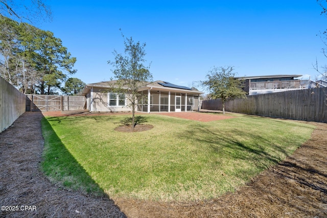 rear view of property with a sunroom, a fenced backyard, a patio, and a lawn