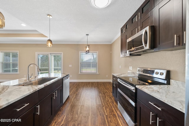 kitchen with appliances with stainless steel finishes, dark wood-style flooring, crown molding, a textured ceiling, and a sink