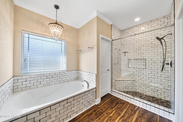 full bathroom with a notable chandelier, wood finished floors, a bath, a stall shower, and crown molding