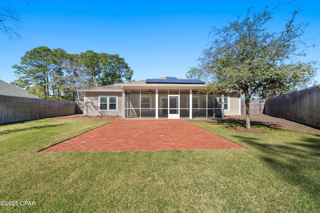 rear view of property featuring a ceiling fan, a patio, a sunroom, a fenced backyard, and a yard