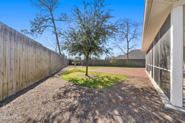 view of yard with a sunroom and a fenced backyard