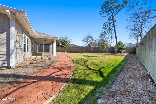 view of yard with ceiling fan, a fenced backyard, and a sunroom