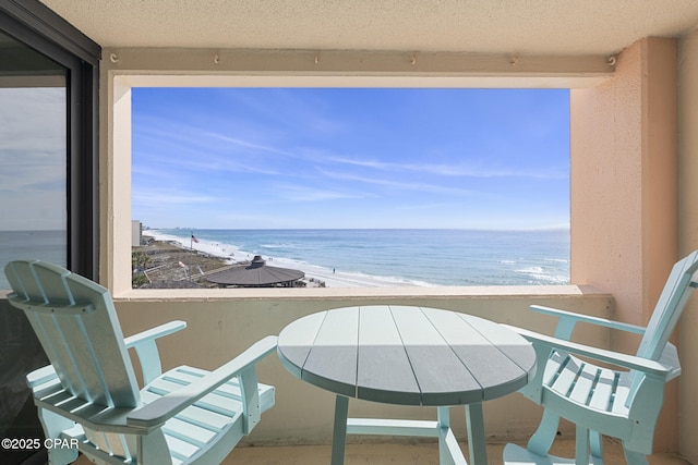 balcony featuring a water view and a view of the beach