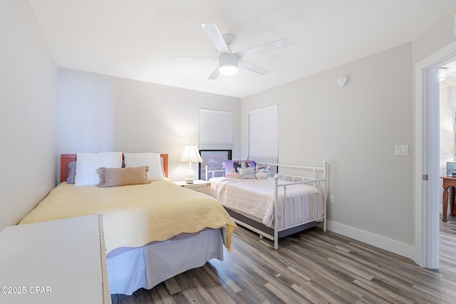 bedroom with wood finished floors, a ceiling fan, and baseboards