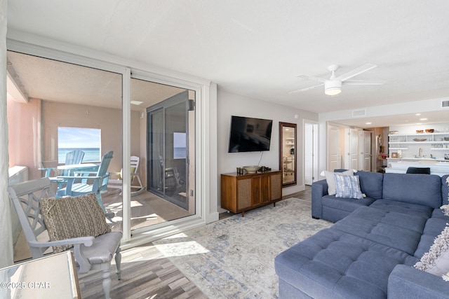 living area featuring wood finished floors, visible vents, and a ceiling fan