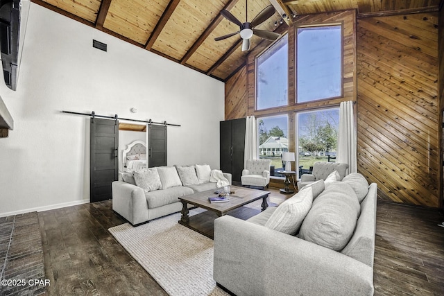 living area featuring a barn door, dark wood-type flooring, wood walls, wooden ceiling, and beamed ceiling