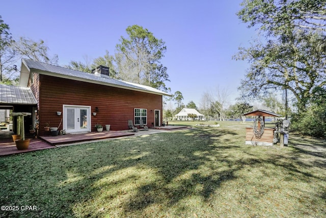 view of yard with french doors, fence, and a deck