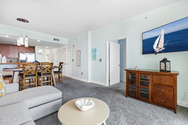 living room with visible vents, baseboards, and carpet floors