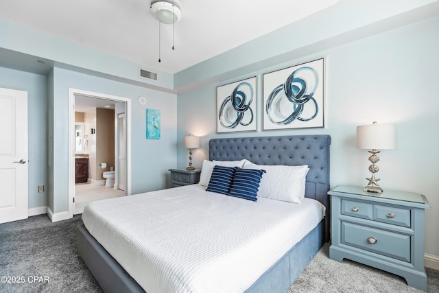 carpeted bedroom featuring visible vents, baseboards, and ensuite bathroom