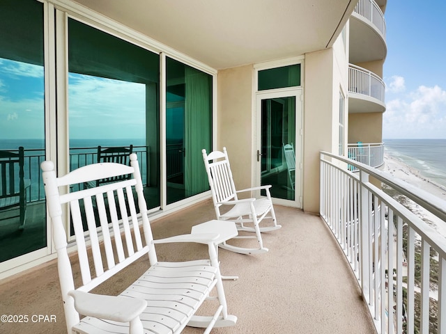 balcony featuring a beach view and a water view