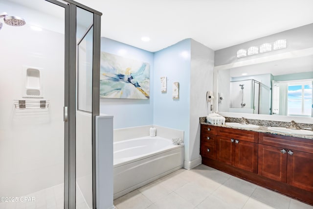full bath featuring a shower stall, a garden tub, tile patterned floors, and a sink