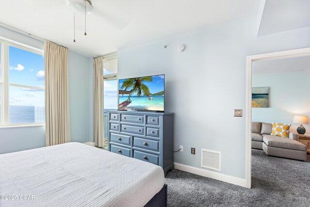 carpeted bedroom with visible vents, multiple windows, and baseboards