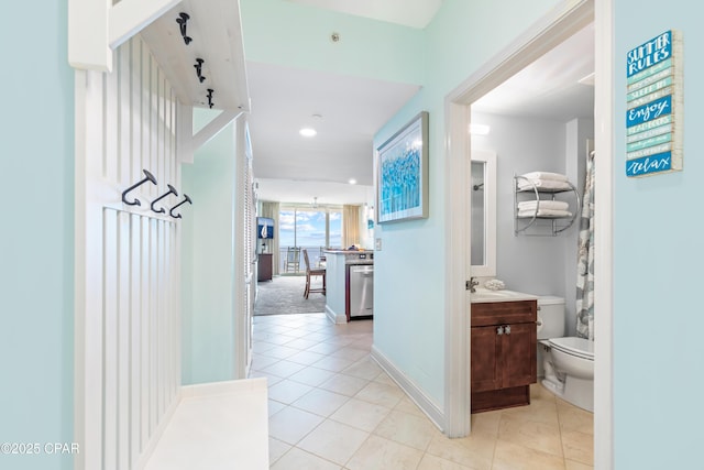 hallway with light tile patterned floors and baseboards