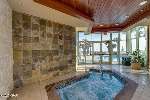 pool with french doors and an indoor hot tub