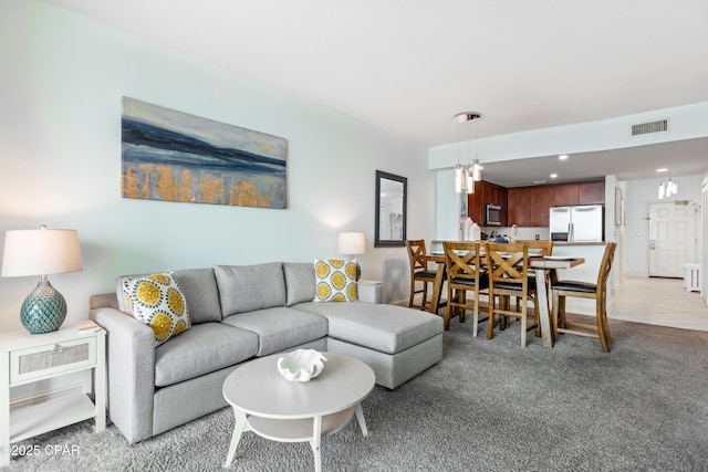 living room with recessed lighting, visible vents, and light carpet