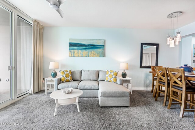 living area with a notable chandelier, baseboards, and carpet floors
