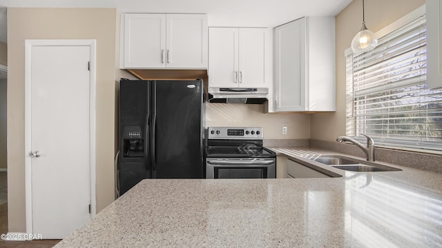 kitchen with under cabinet range hood, light stone counters, electric stove, black refrigerator with ice dispenser, and a sink