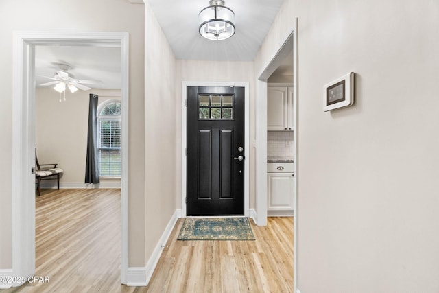 foyer entrance featuring light wood-style floors and baseboards