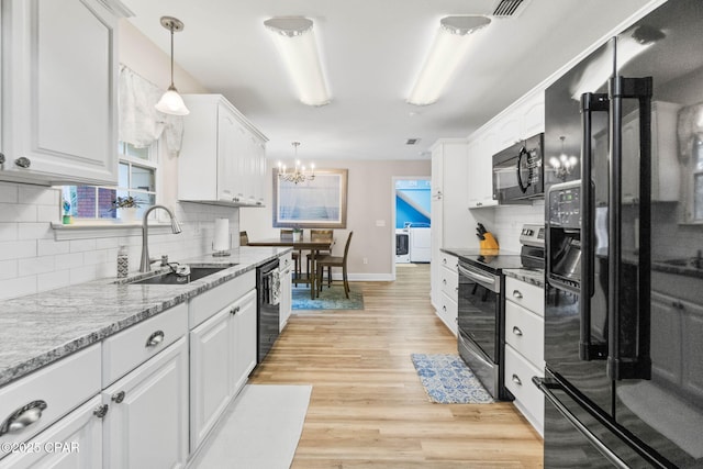 kitchen with black appliances, white cabinetry, and decorative light fixtures