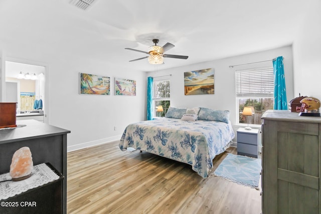 bedroom featuring visible vents, ensuite bathroom, light wood-style floors, ceiling fan, and baseboards