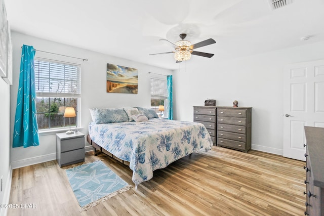 bedroom featuring light wood-style flooring, visible vents, and baseboards