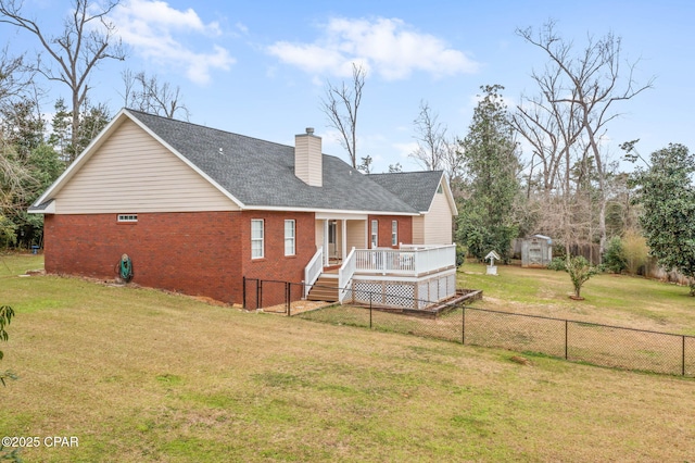 rear view of property with a chimney, a storage unit, a lawn, and brick siding