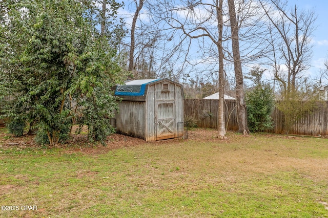 view of yard featuring a storage unit, fence, and an outbuilding