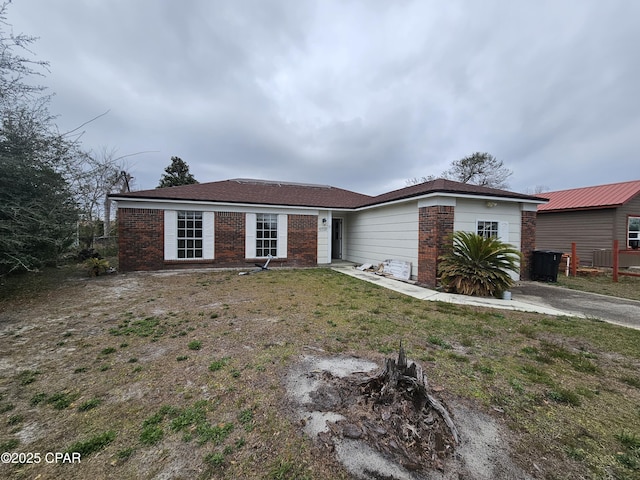 ranch-style home featuring brick siding and a front lawn