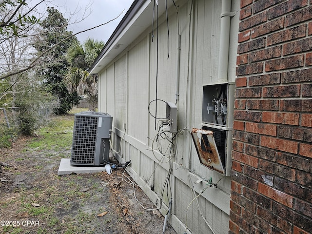 view of side of home featuring central AC unit and brick siding