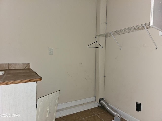 washroom featuring dark tile patterned flooring and baseboards