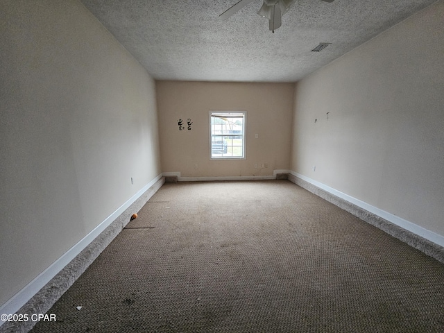 spare room featuring baseboards, visible vents, ceiling fan, a textured ceiling, and carpet floors