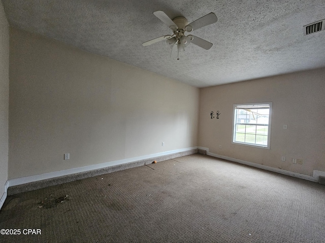 carpeted empty room with visible vents, ceiling fan, a textured ceiling, and baseboards