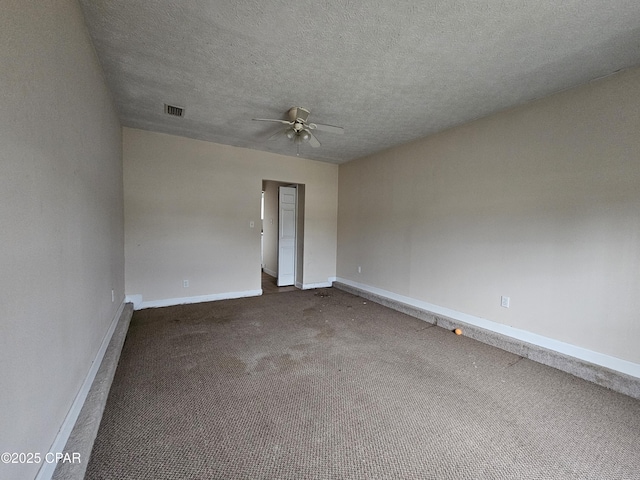 empty room with dark colored carpet, visible vents, ceiling fan, a textured ceiling, and baseboards