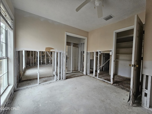 unfurnished bedroom with visible vents, ceiling fan, and a textured ceiling