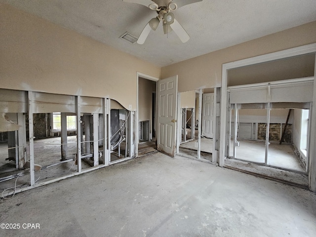 interior space featuring a ceiling fan, visible vents, and multiple closets