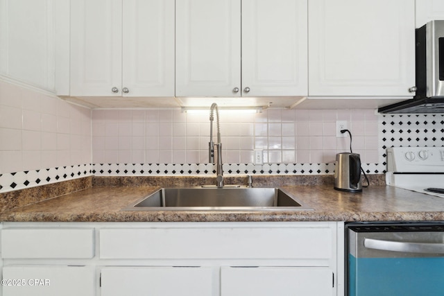 kitchen featuring a sink, stainless steel appliances, dark countertops, and white cabinetry