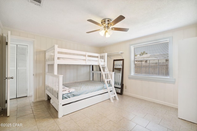 unfurnished bedroom with tile patterned floors, visible vents, a textured ceiling, and a ceiling fan