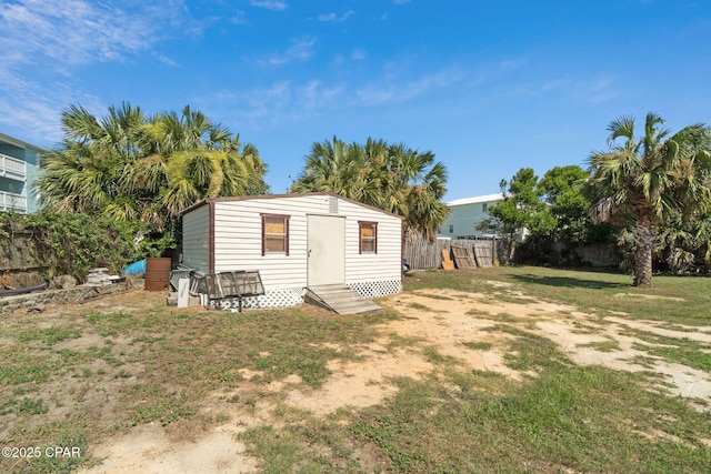 view of outbuilding with an outbuilding, entry steps, and fence