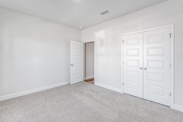 unfurnished bedroom with baseboards, a closet, visible vents, and carpet flooring