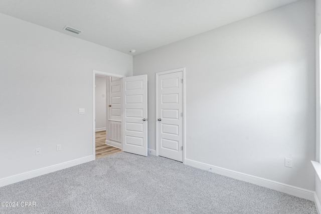 unfurnished bedroom featuring carpet, visible vents, and baseboards